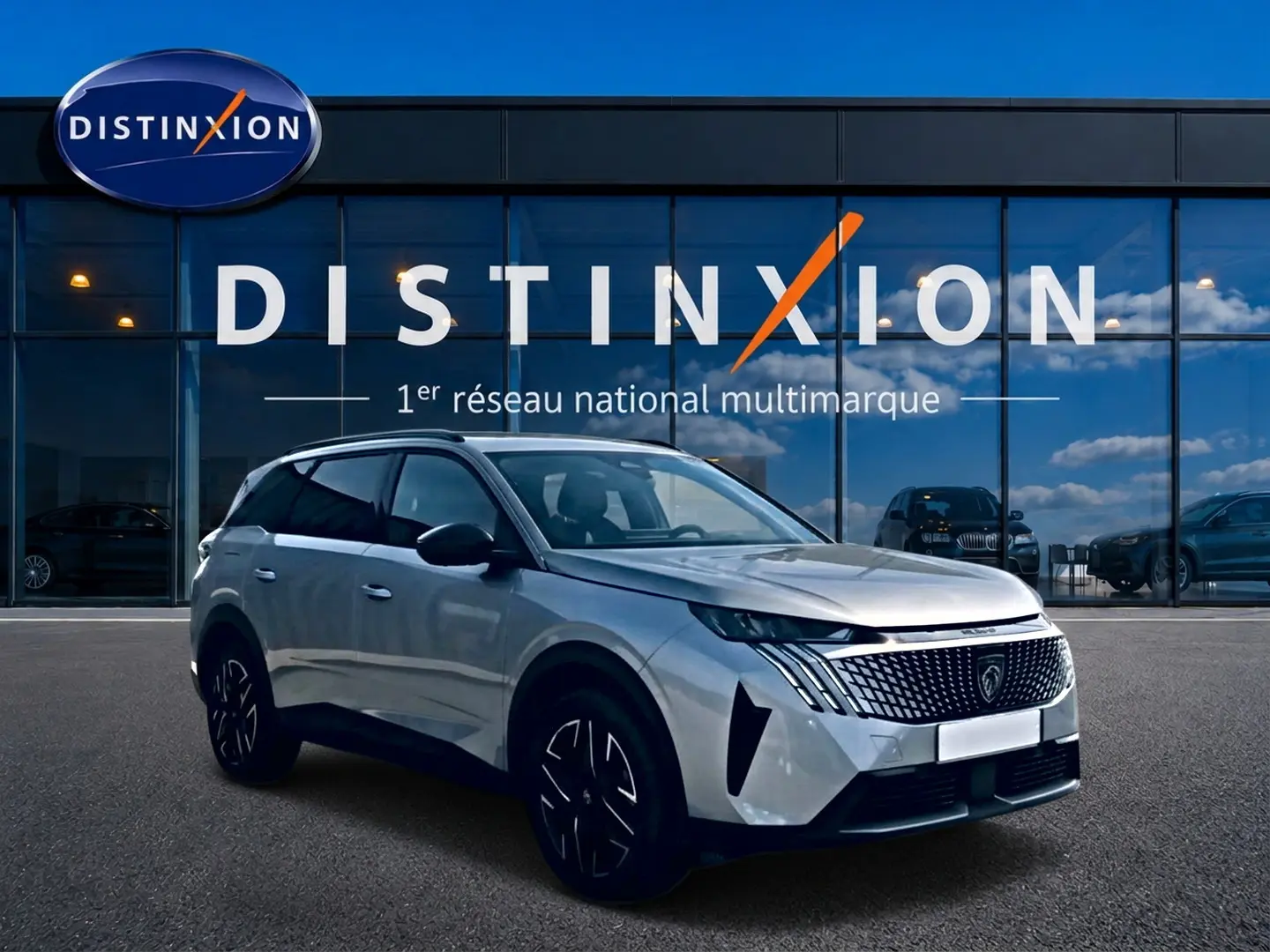 Peugeot 5008 gris artense en 3/4 avant droit, avec calandre distinctive et jantes alu noires.