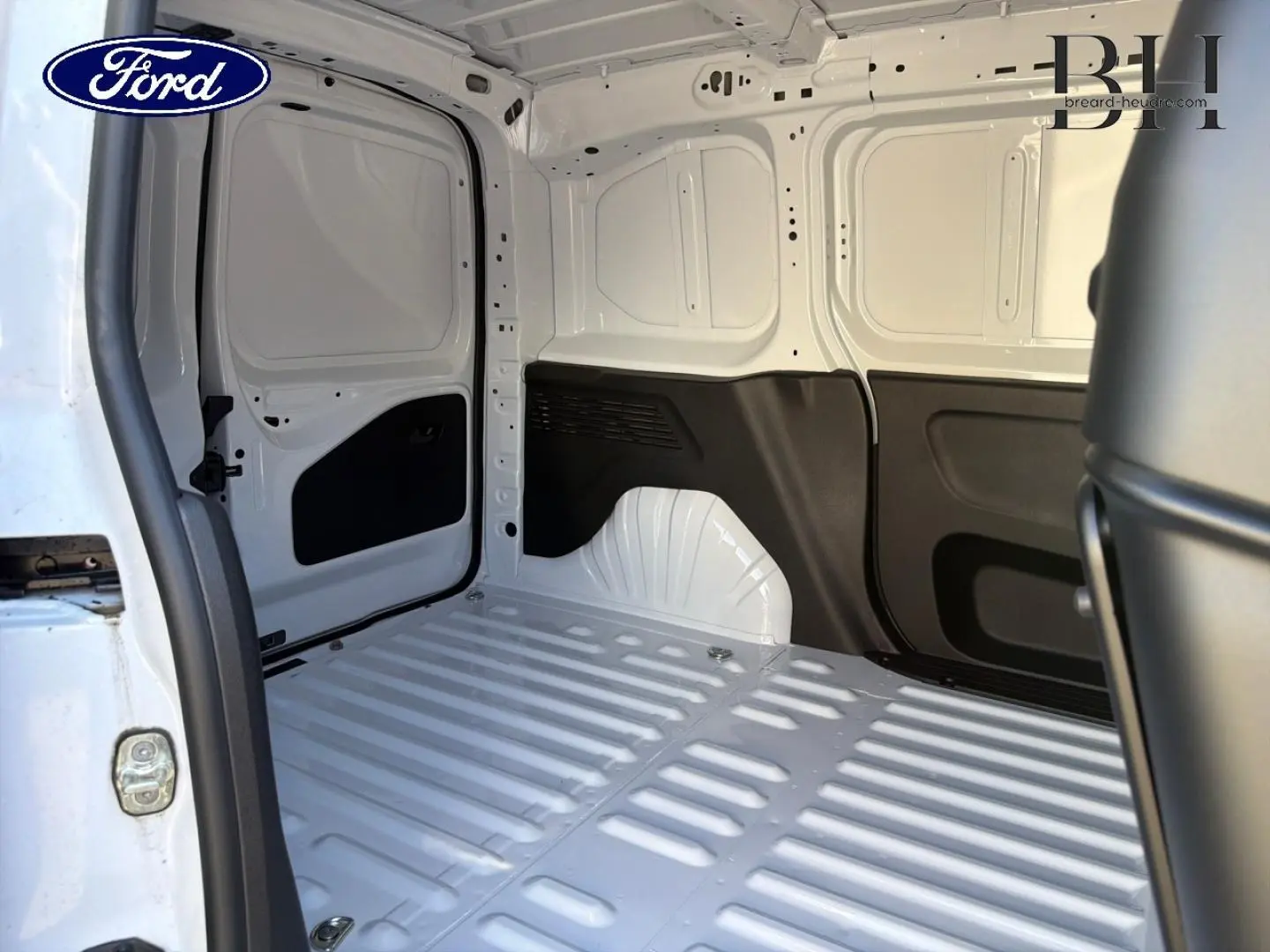 Vue intérieure arrière du coffre blanc Icy du Peugeot Partner 2025, montrant la cloison pleine et les parois métalliques.