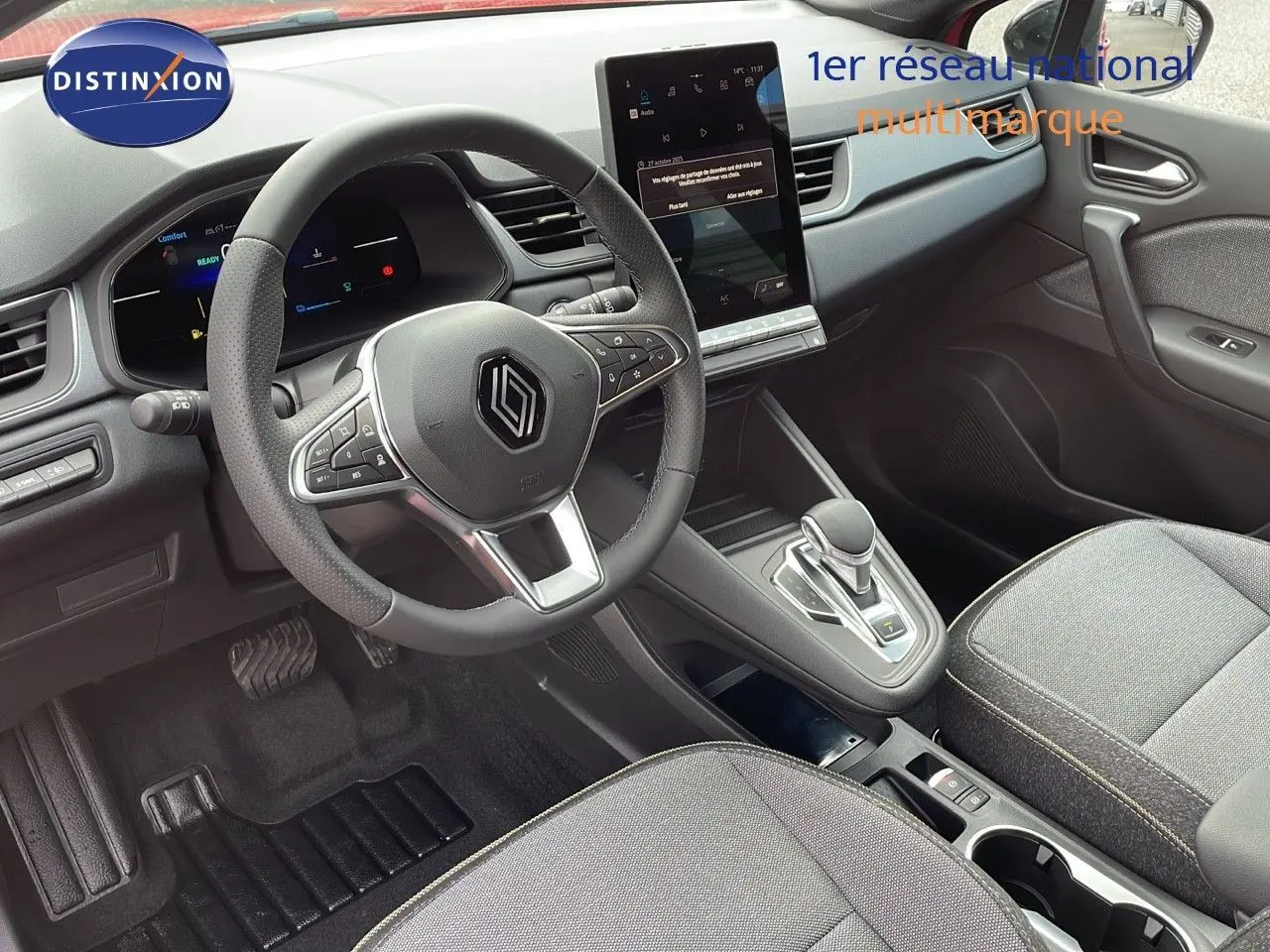 Intérieur du Renault Captur E-Tech hybride 2025, vue du poste de conduite avec volant multifonction et écran tactile central.