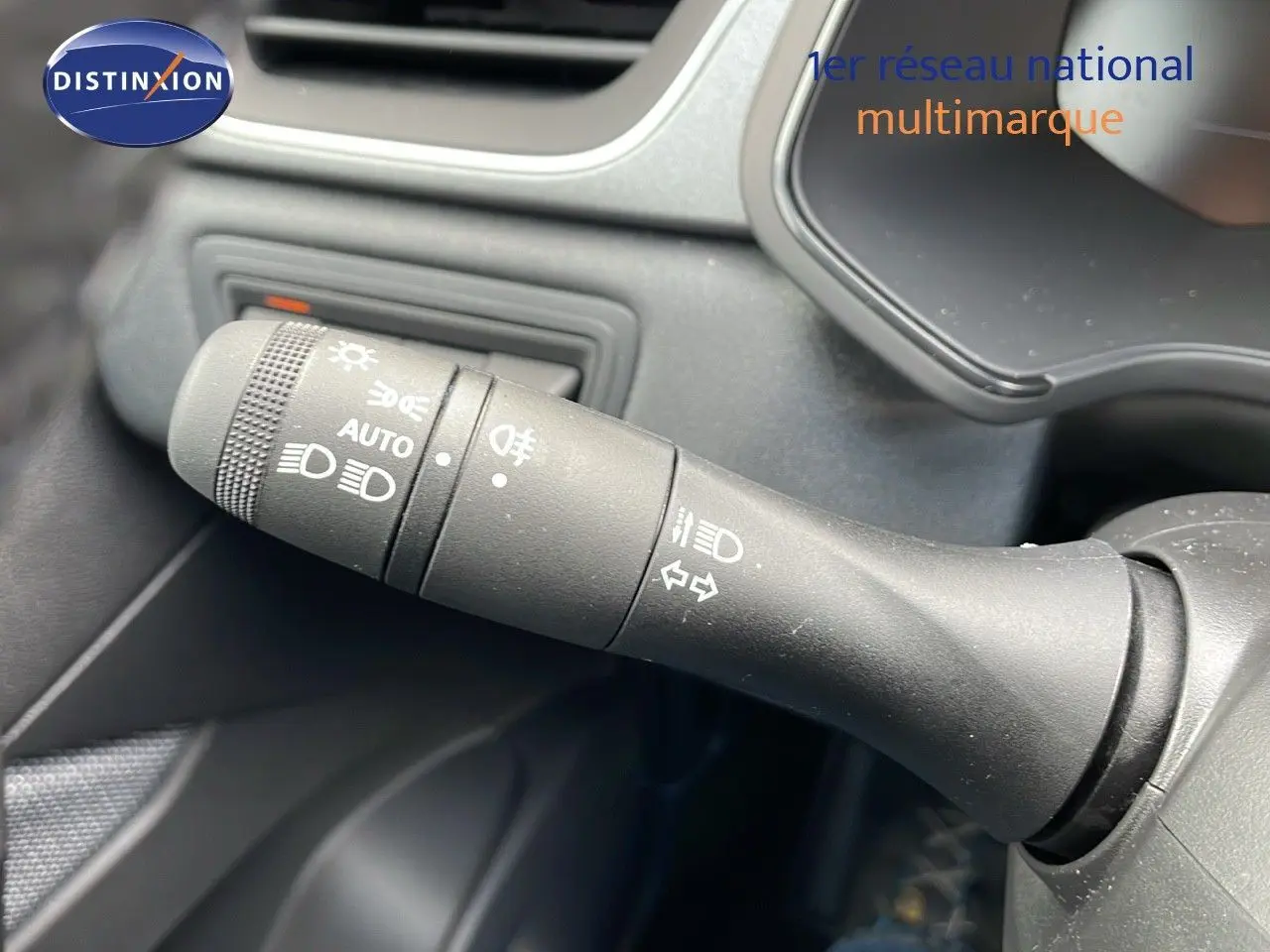Gros plan sur la commande des feux et clignotants du Renault Captur E-Tech hybride 2025, intérieur noir.