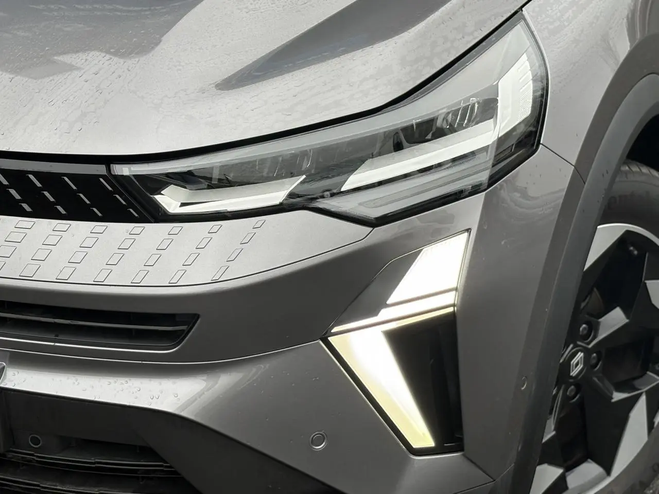 Gros plan sur l'avant droit du Renault Captur gris Cassiopée avec feux LED et jante alu noire diamantée.