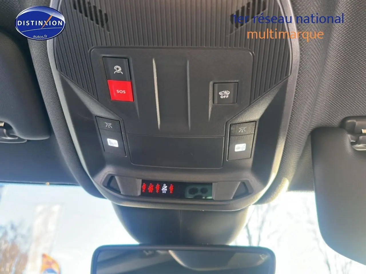 Vue intérieure en plongée sur la console de toit noire avec boutons SOS et contrôle d'assistance du Peugeot 408 Hybrid 145 GT.