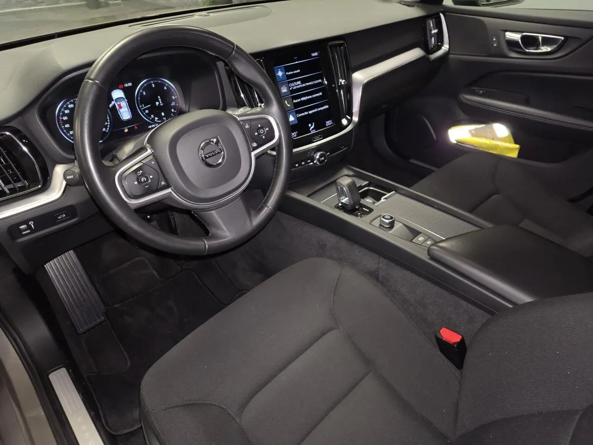 Intérieur avant droit de la Volvo V60 B4 2021, montrant le volant, tableau de bord digital et console centrale noire.