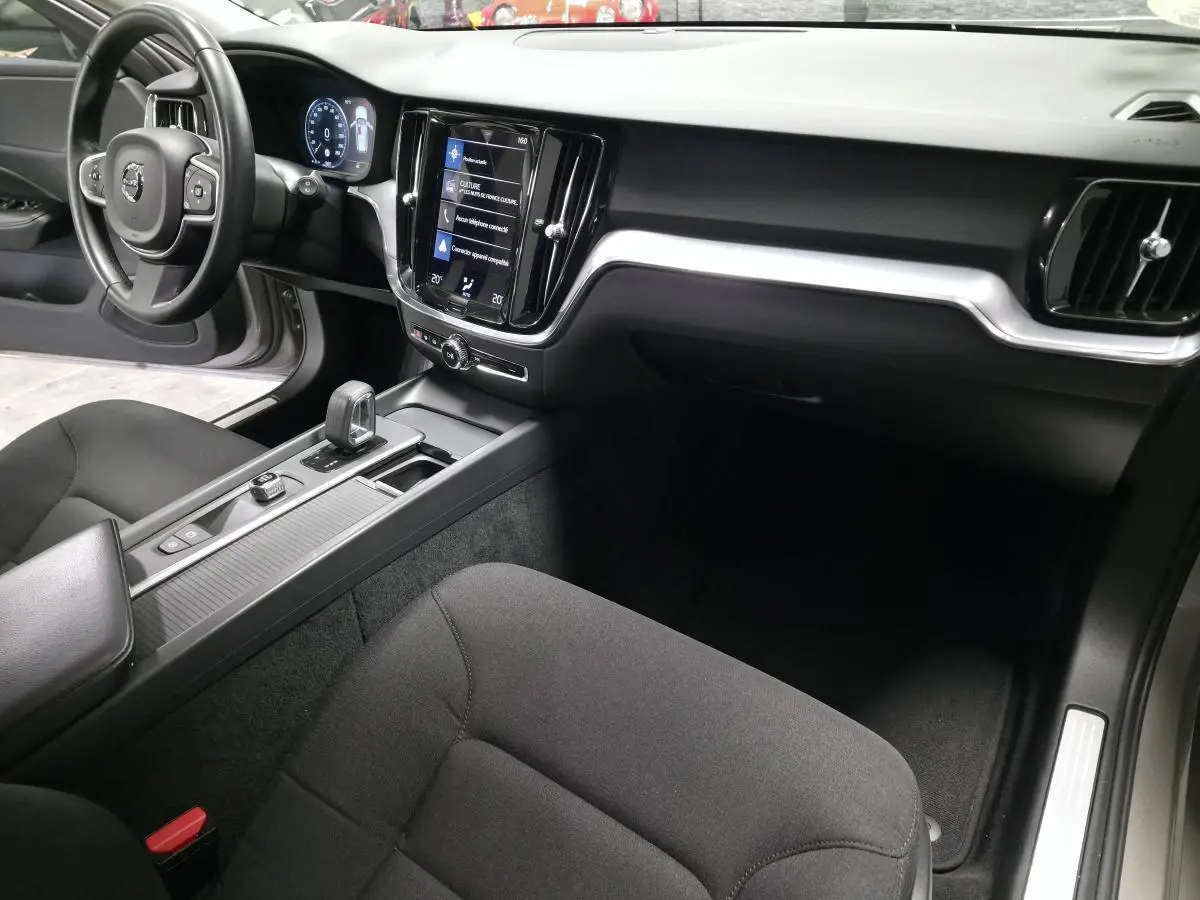 Vue intérieure côté passager du tableau de bord et console centrale noire du Volvo V60 B4 2021 avec écran tactile vertical.