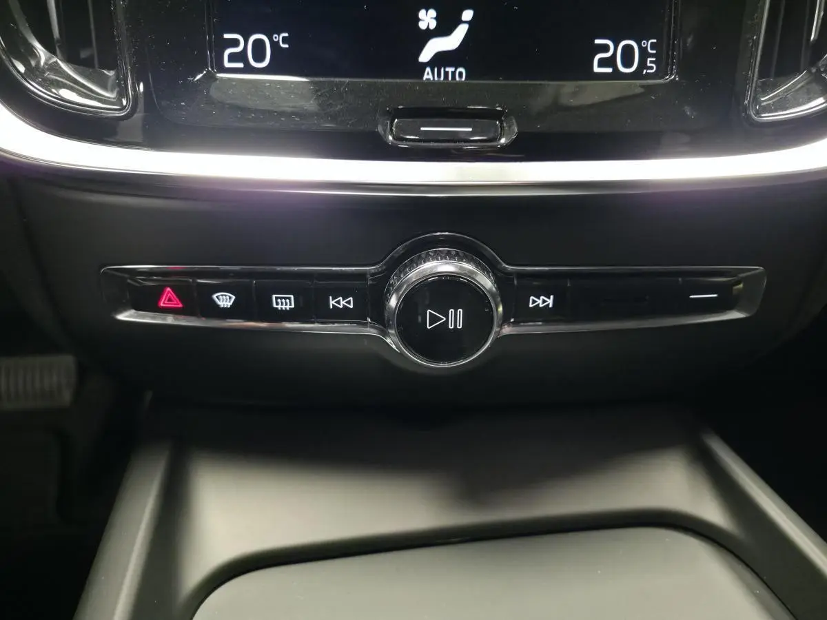 Gros plan sur la console centrale du Volvo V60 2021, boutons de commande audio et climatisation affichant 20°C.