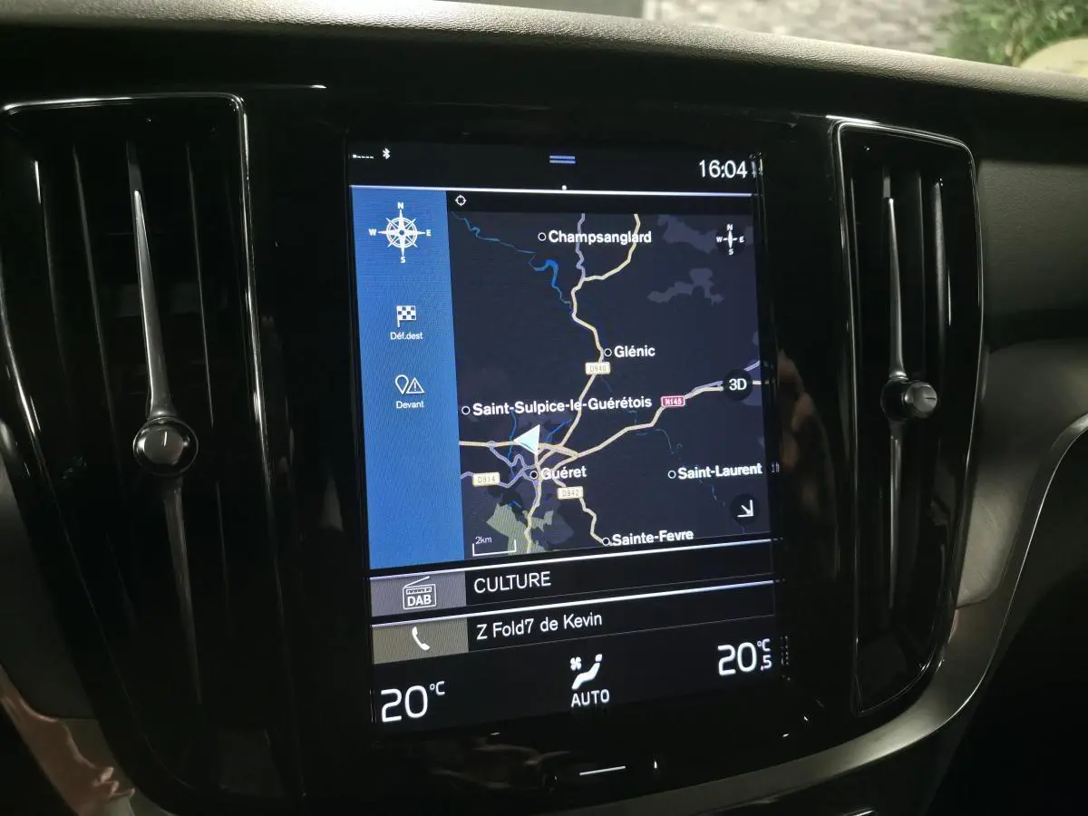 Vue rapprochée de l'écran tactile multimédia central du tableau de bord de la Volvo V60 gris, affichant la navigation GPS.