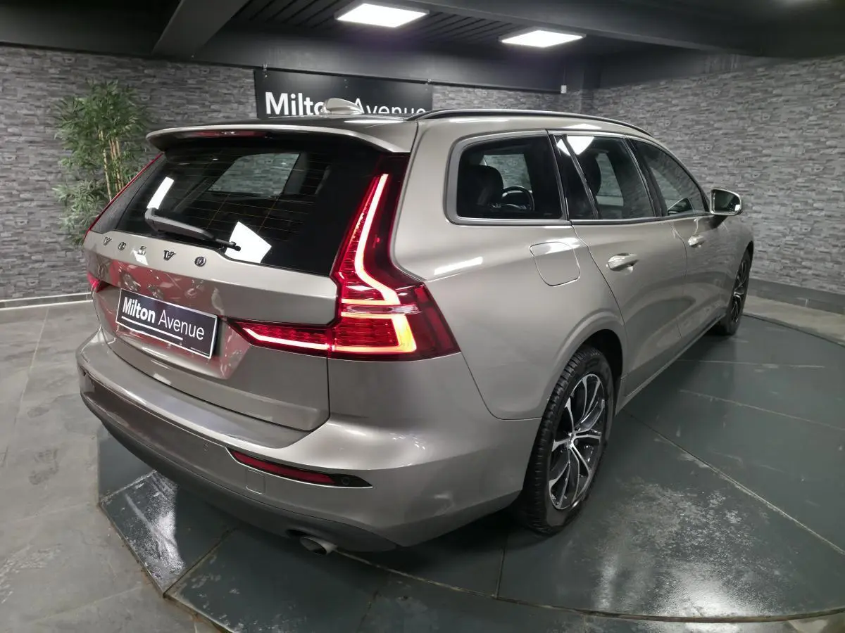 Vue 3/4 arrière droite d'un Volvo V60 gris métallisé avec feux arrière LED en forme de L et jantes alliage 17 pouces.