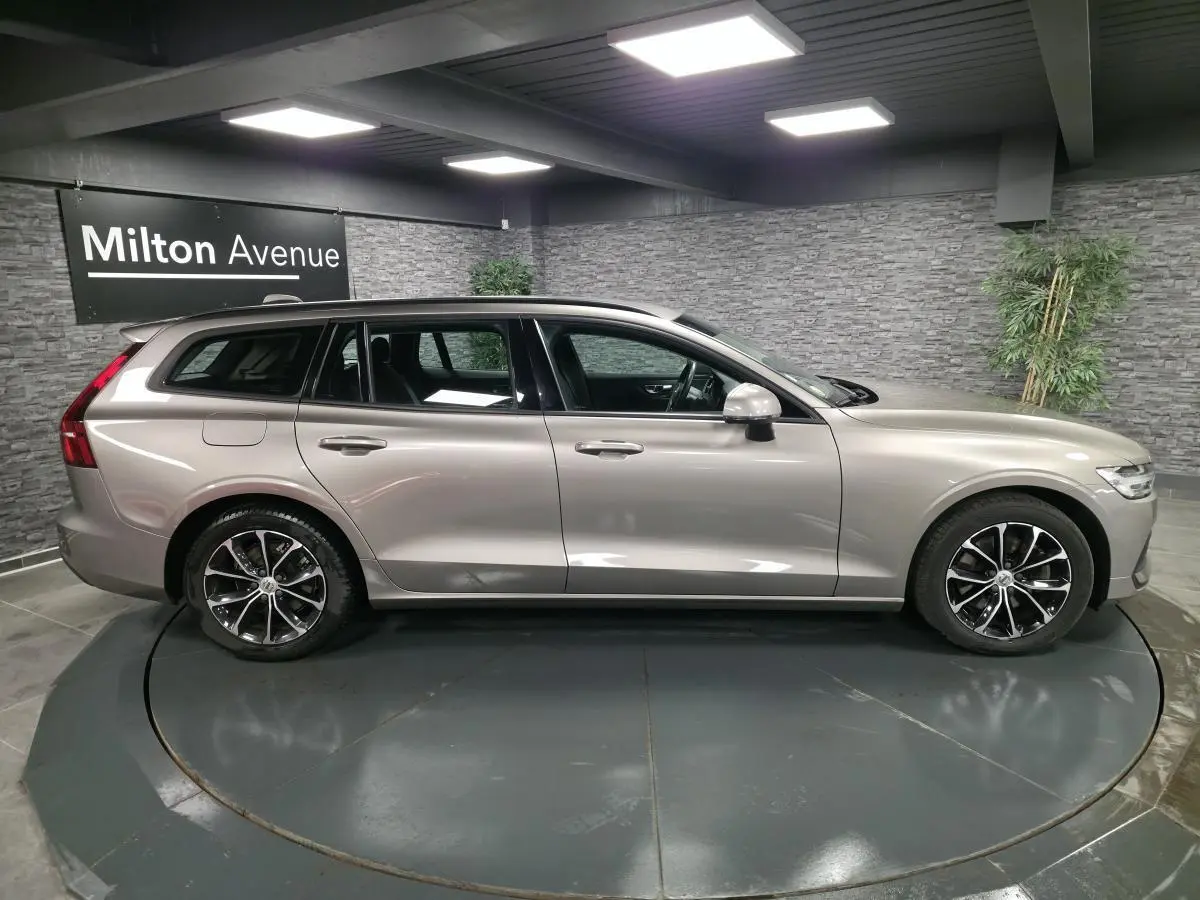Volvo V60 gris métallisé vue de profil côté gauche, avec jantes alliage 17 pouces et toit noir.