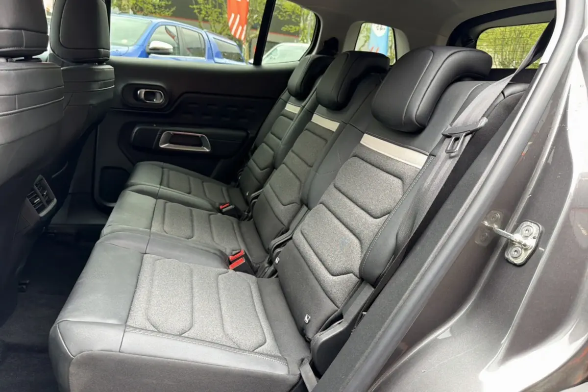 Vue intérieure côté droit des trois sièges arrière individuels en tissu gris du Citroën C5 Aircross Hybrid 2025.
