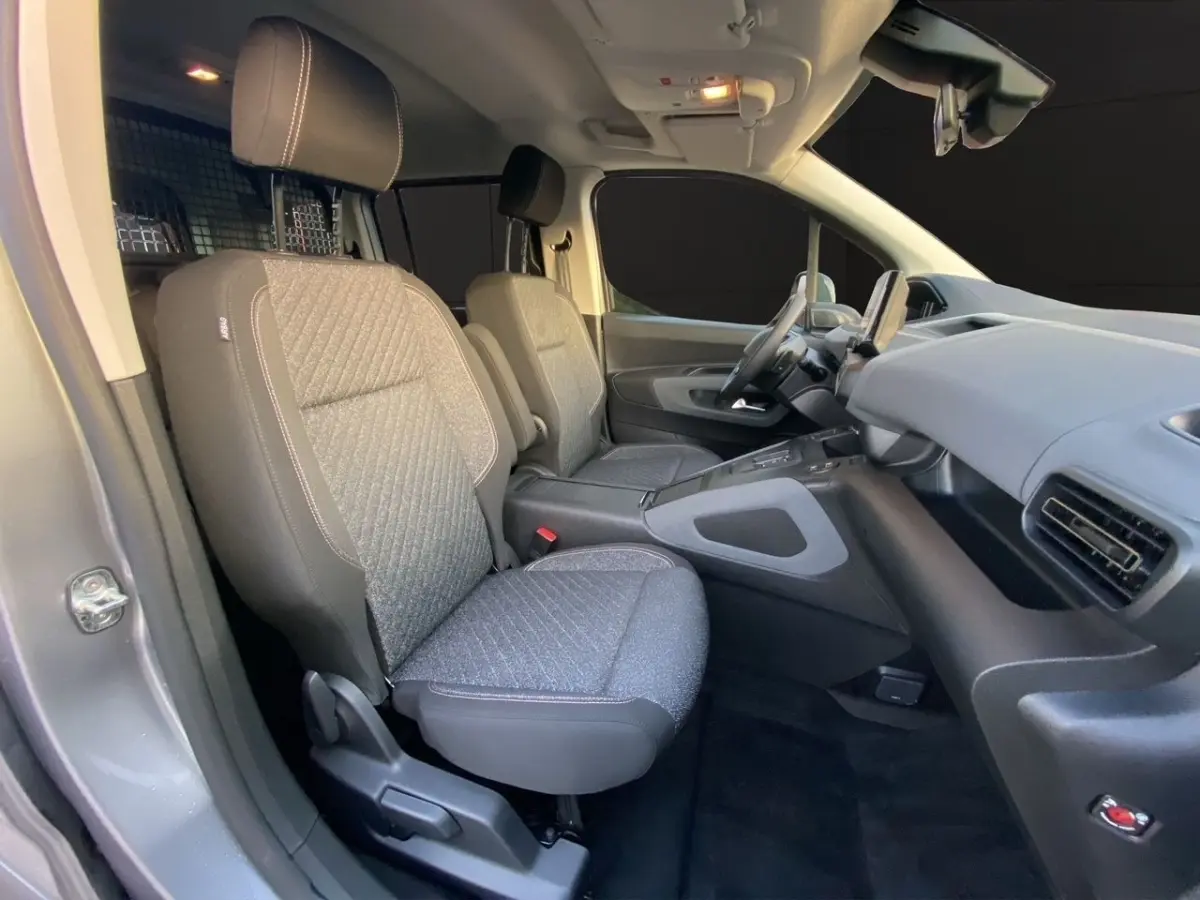 Vue intérieure côté droit du Peugeot Rifter gris clair 2026, montrant les sièges avant et le tableau de bord moderne.