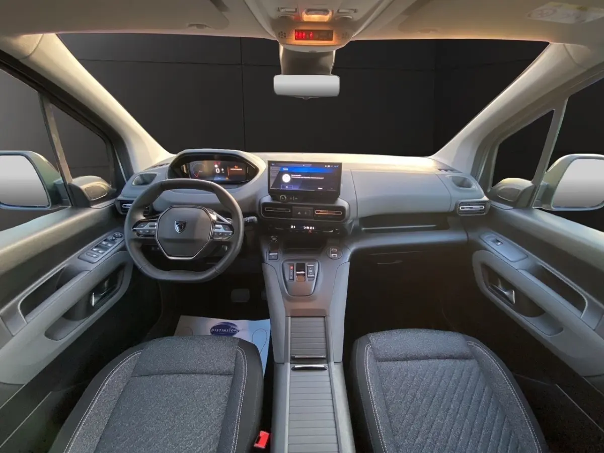 Vue intérieure avant du Peugeot Rifter gris clair 2026, avec tableau de bord moderne et écran tactile central.