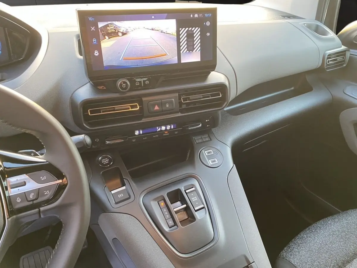 Vue intérieure du tableau de bord et console centrale du Peugeot Rifter gris clair, avec écran tactile affichant la caméra de recul.