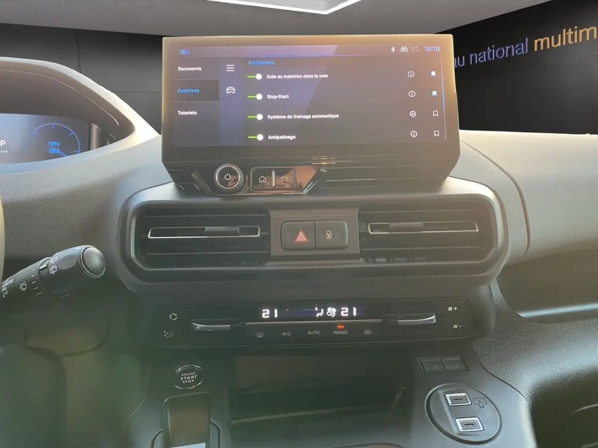 Vue intérieure du tableau de bord du Peugeot Rifter gris clair 2026, avec écran tactile central et commandes climatisation.