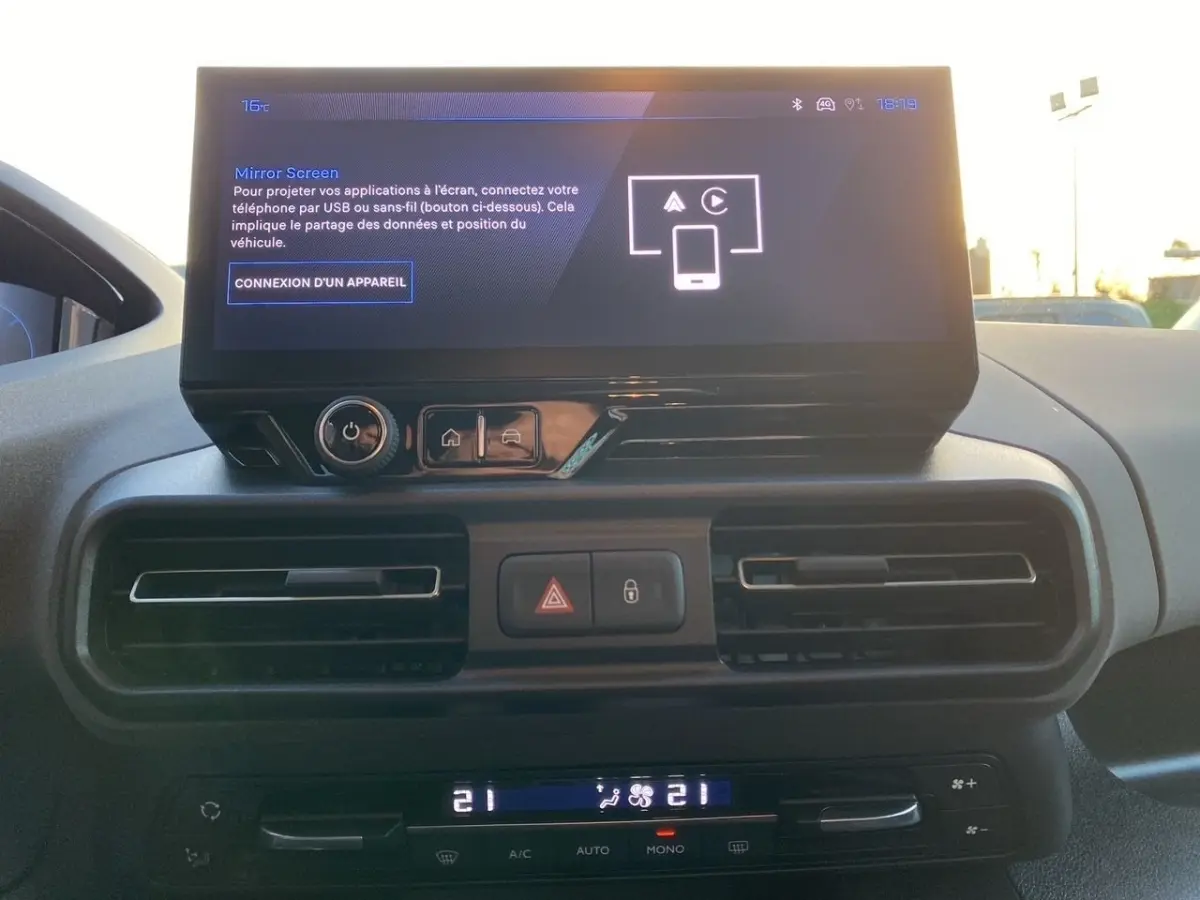 Vue frontale du tableau de bord du Peugeot Rifter gris clair 2026 avec écran tactile central et commandes climatisation digitales.