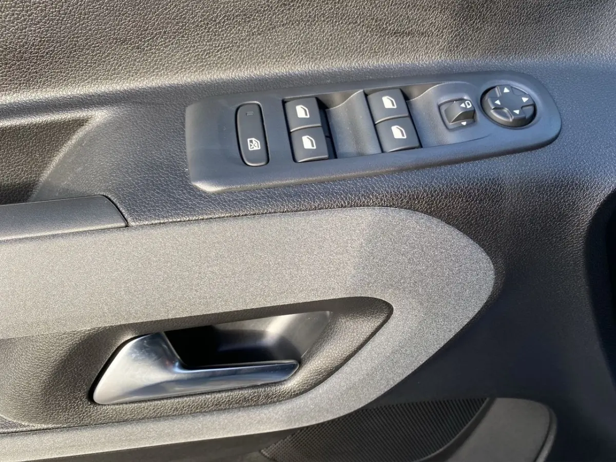 Gros plan sur la commande des vitres et rétroviseurs côté conducteur du Peugeot Rifter gris clair 2026.