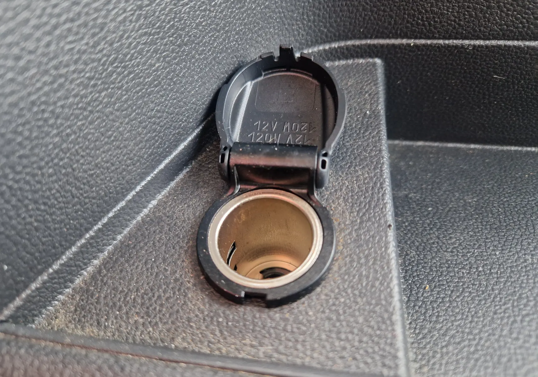 Prise allume-cigare 12V ouverte sur la console intérieure noire du Renault Master Châssis Cabine blanc 2024.