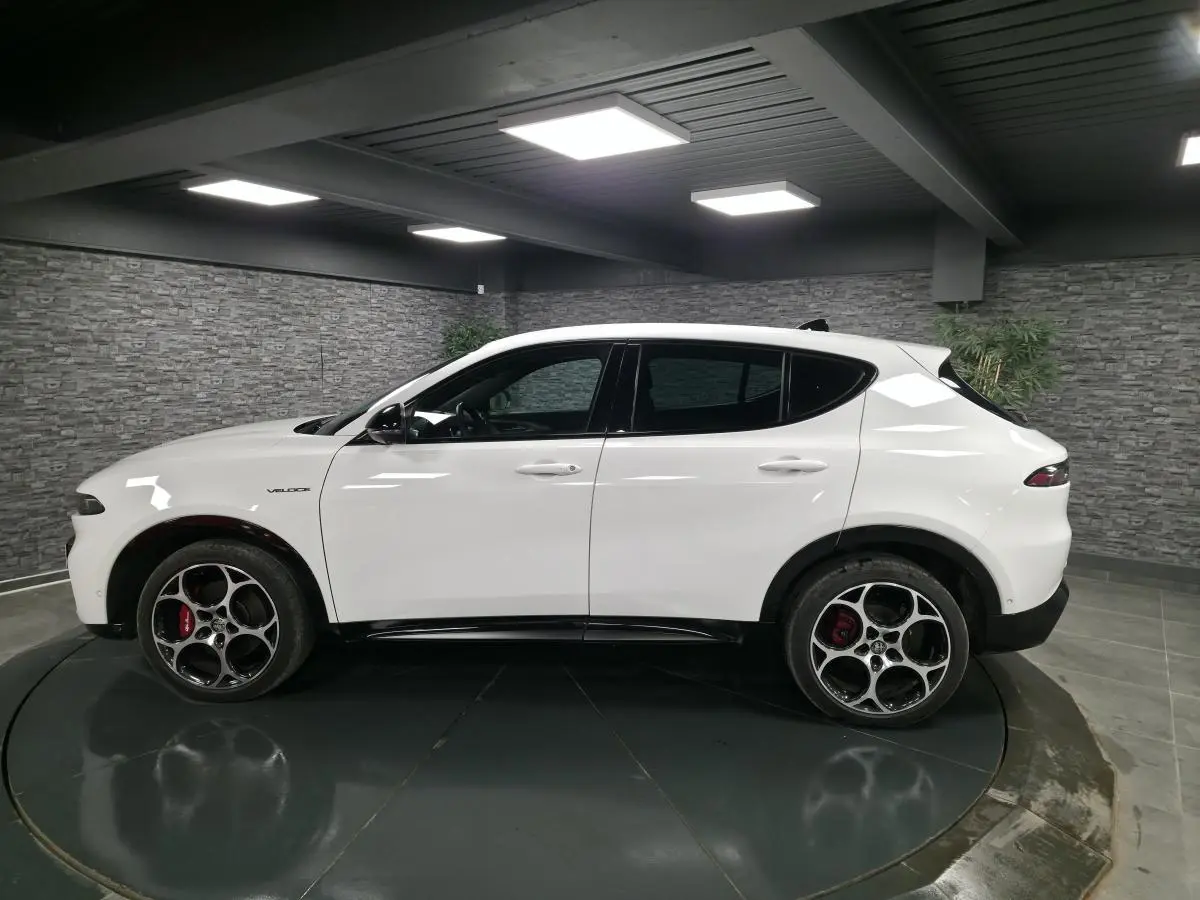Vue de profil côté gauche d'un Alfa Romeo Tonale blanc avec jantes alliage 19 pouces et étriers de frein rouges.