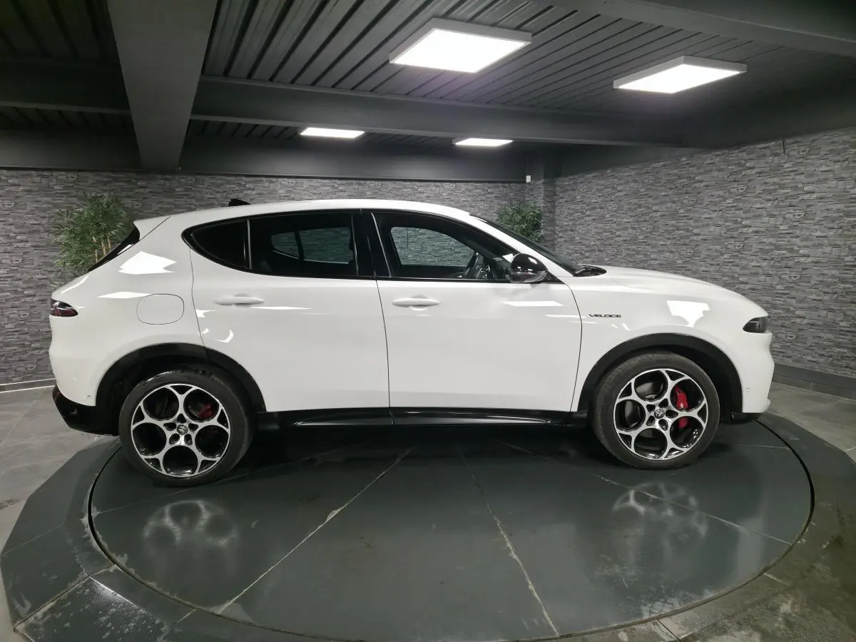 Vue de profil côté gauche d'une Alfa Romeo Tonale blanche avec jantes alliage 19 pouces et étriers de frein rouges.