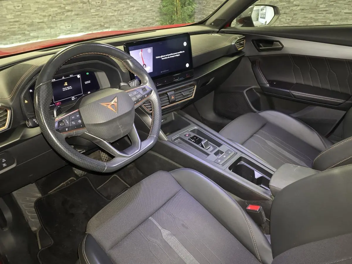 Intérieur de la CUPRA Formentor vu côté conducteur, avec volant sport, écran tactile et sellerie noire aux surpiqûres cuivre.