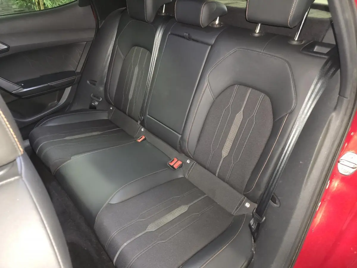 Vue intérieure du siège arrière droit en textile noir avec surpiqûres orange du CUPRA Formentor rouge 2022.