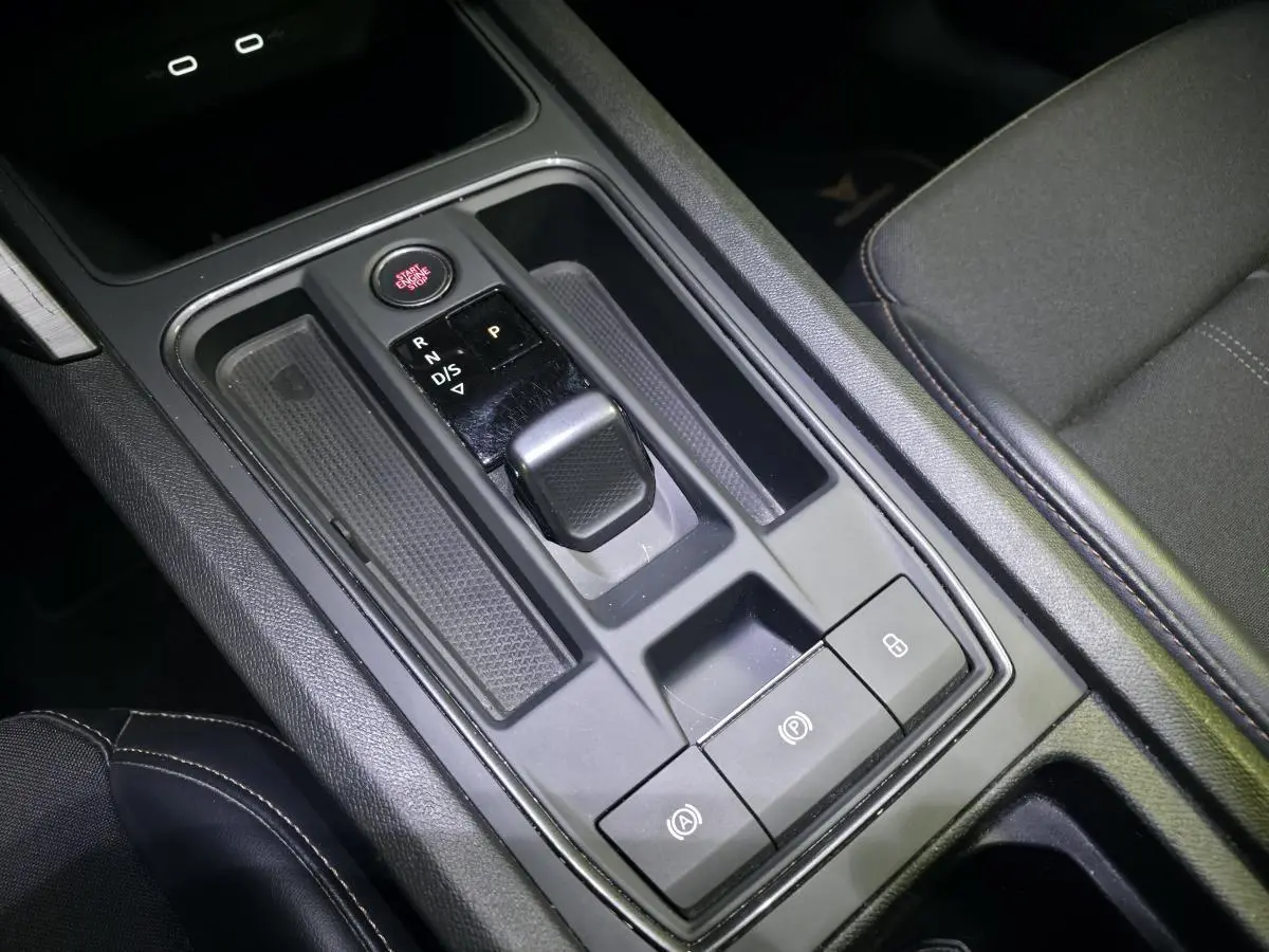 Vue rapprochée de la console centrale noire du CUPRA Formentor avec levier de vitesse automatique et bouton start/stop rouge.