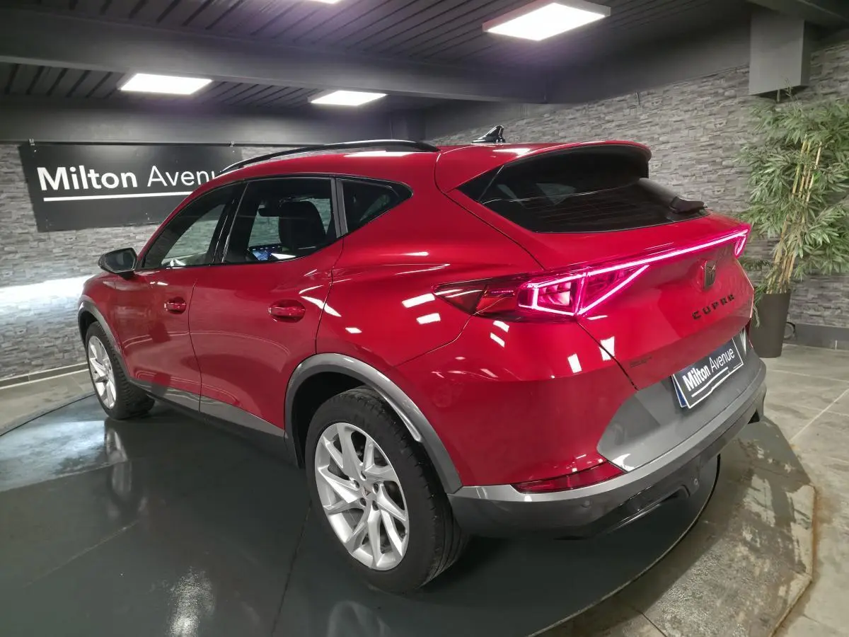 Vue 3/4 arrière droite du CUPRA Formentor rouge avec bandeau lumineux LED et jantes alliage 18 pouces.