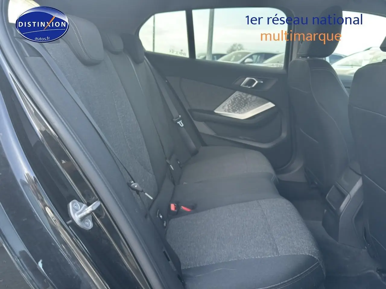Vue intérieure côté gauche de la banquette arrière en tissu anthracite d'une BMW Série 1 noire 2024.