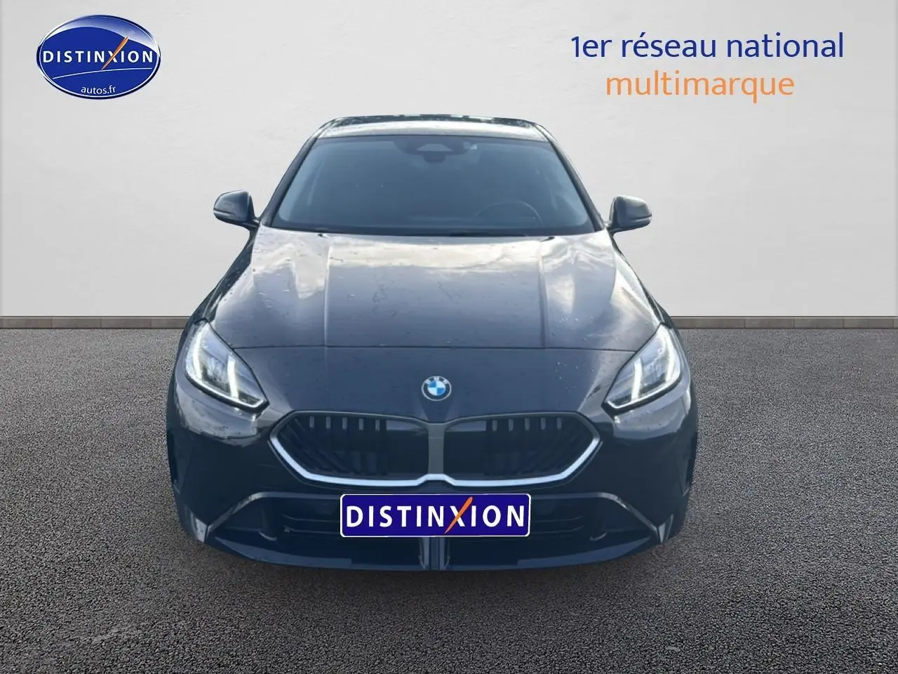 Vue avant d'une BMW Série 1 noire 2024 avec calandre double haricot et phares LED allumés.
