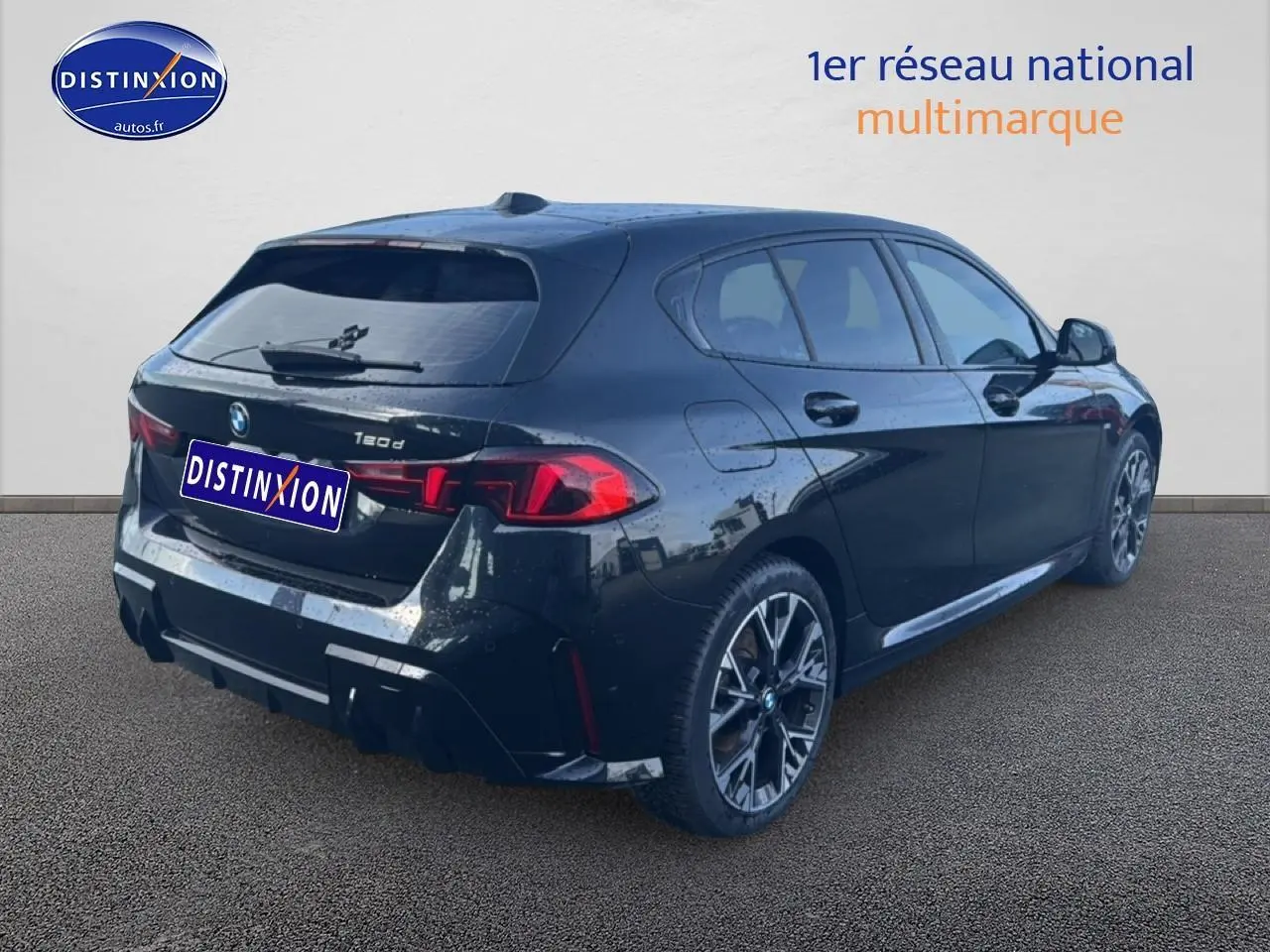 BMW Série 1 noire vue 3/4 arrière droit, avec jantes alu et feux arrière LED distinctifs.