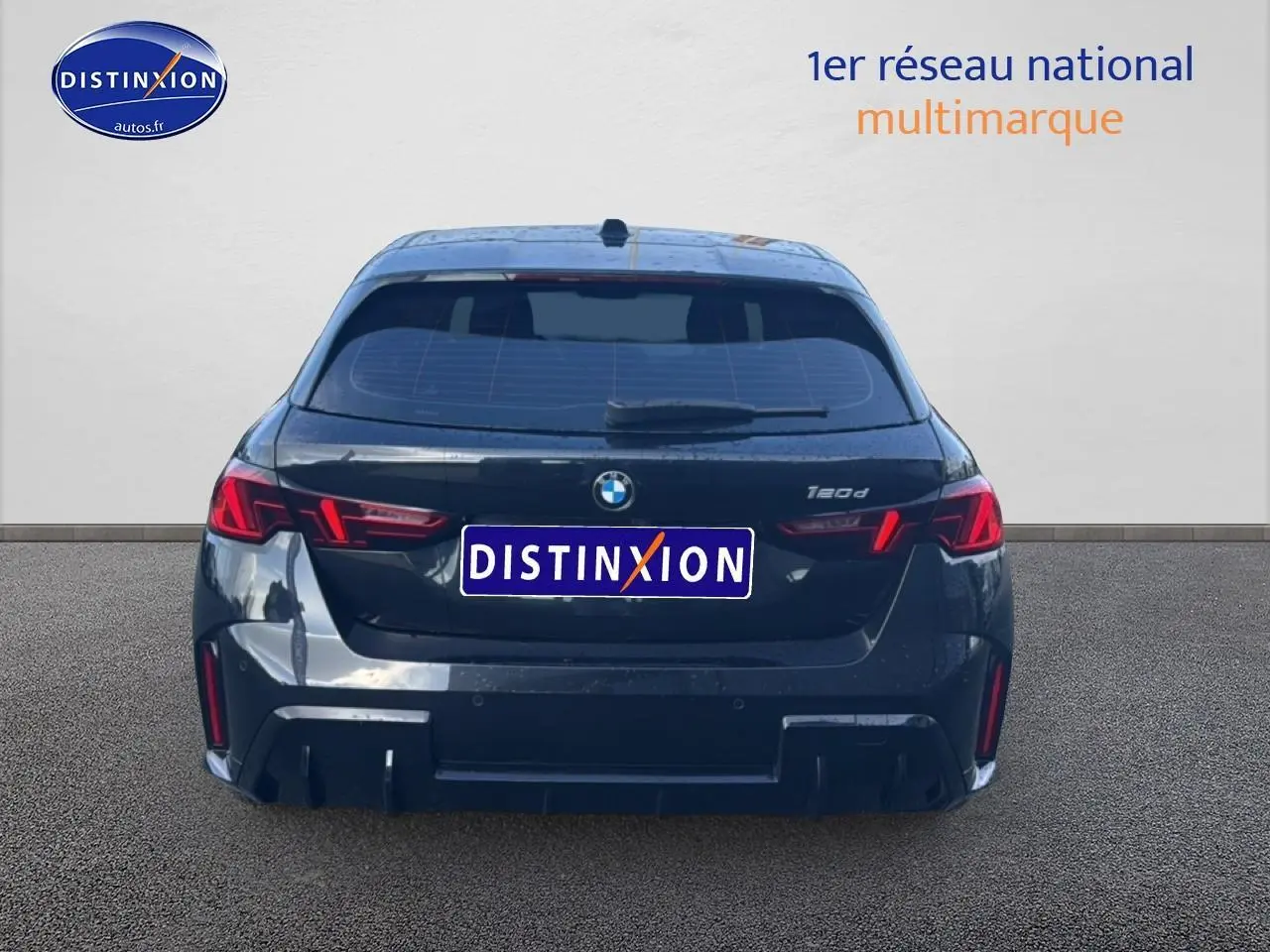 Vue arrière d'une BMW Série 1 noire 2024 avec feux LED et logo distinctif au centre du hayon.