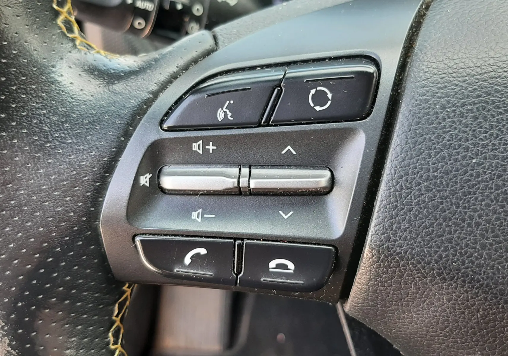 Détail du volant côté gauche du Hyundai Kona gris 2018, avec commandes audio et téléphone intégrées.