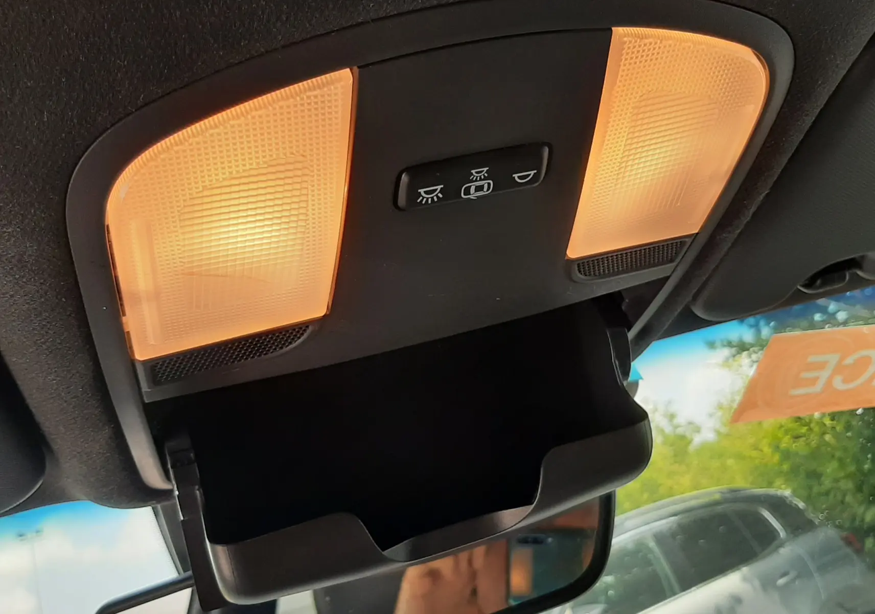 Plafonnier intérieur allumé avec rangement lunettes ouvert, vue vers l'avant du Hyundai Kona gris de 2018.