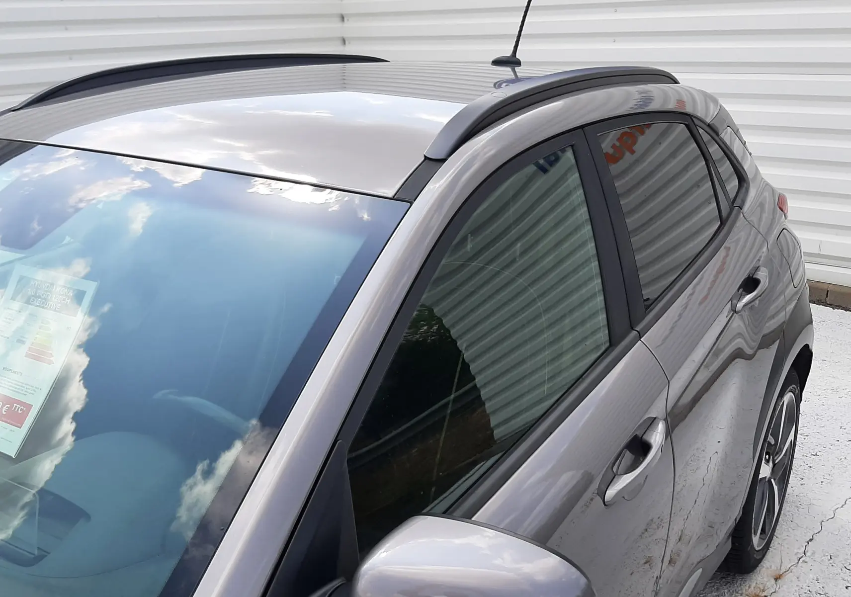 Vue 3/4 avant droit d'une Hyundai Kona gris métallisé 2018 avec toit noir et jantes alliage bicolores.