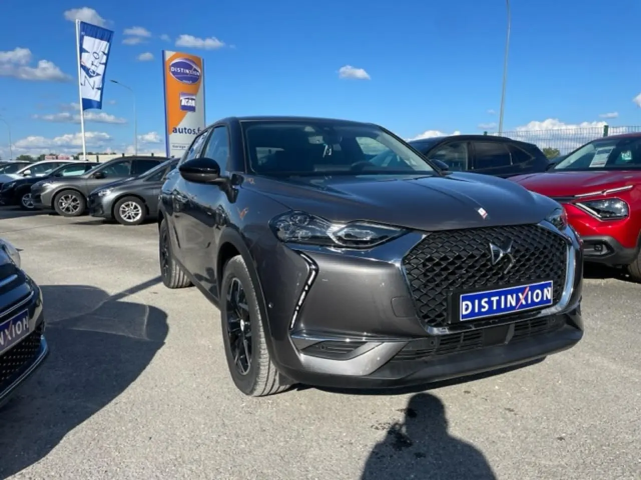 DS3 Crossback E-Tense gris platinium en 3/4 avant, avec calandre noire distinctive et jantes noires.