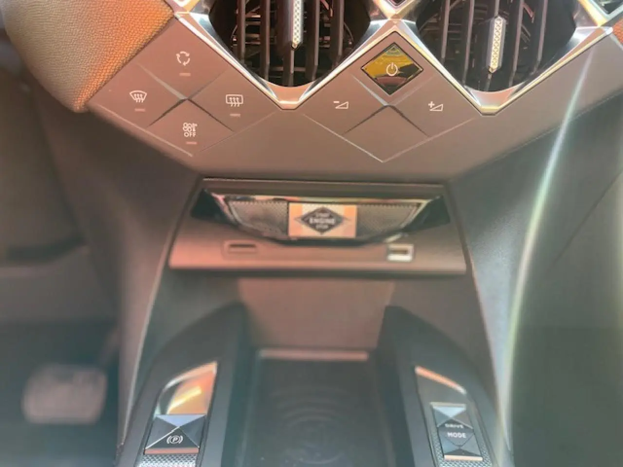 Gros plan sur la console centrale du DS3 Crossback E-Tense 2021, mettant en valeur les commandes et la zone de recharge sans fil.