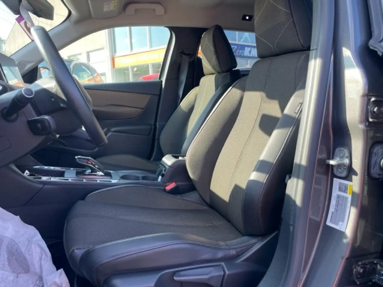 Vue intérieure côté conducteur du DS3 Crossback E-Tense gris platinium, montrant les sièges avant et la console centrale.