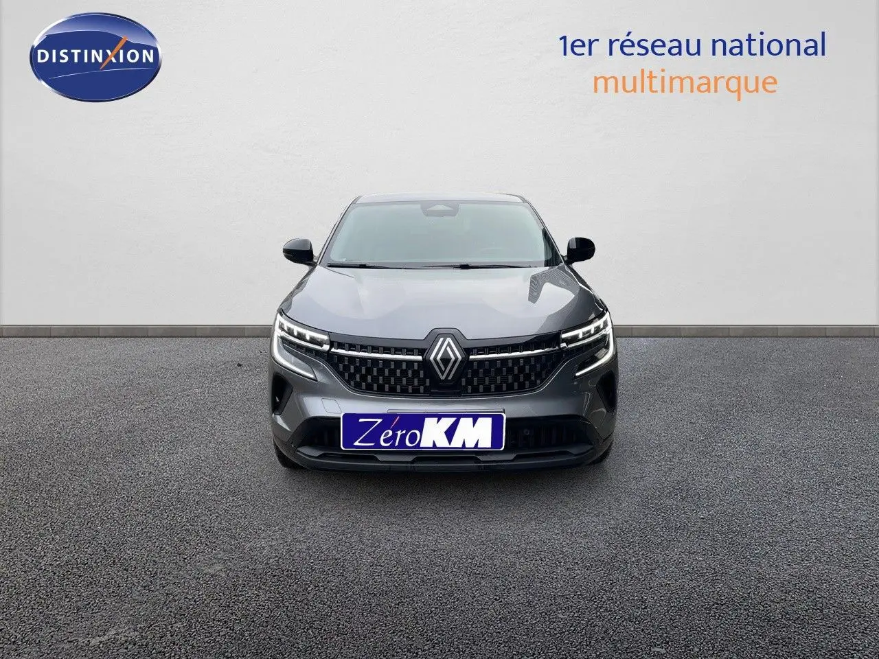 Vue frontale d'un Renault Austral gris schiste métal avec calandre noire et feux LED allumés sur fond neutre.