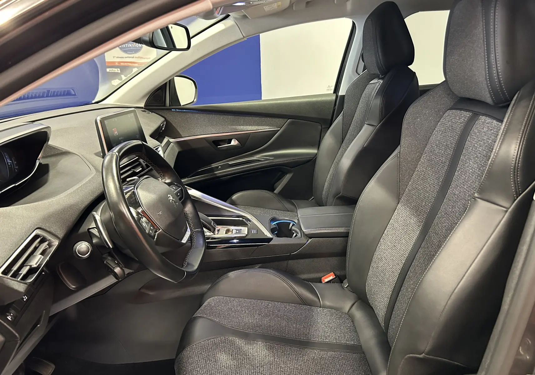 Intérieur avant du Peugeot 5008 gris 2020, sièges chauffants en cuir et tissu, tableau de bord moderne avec écran tactile.
