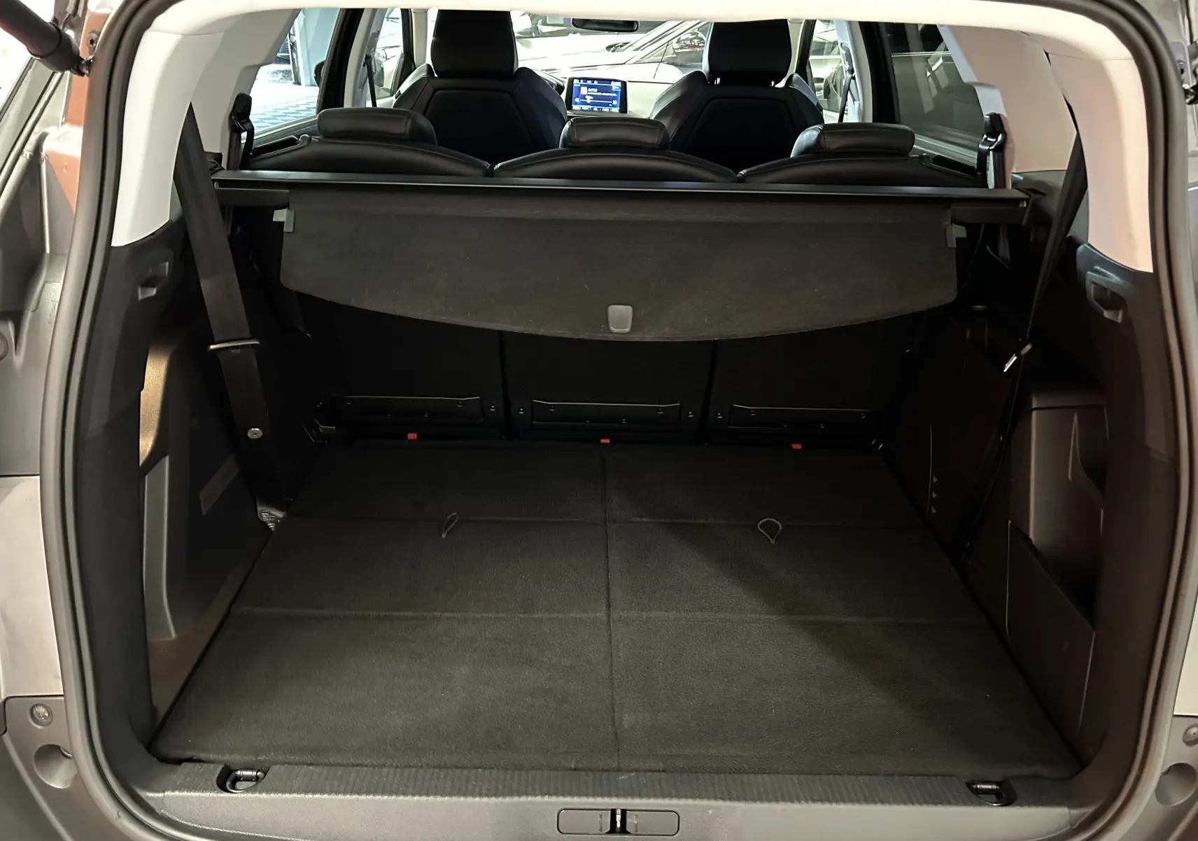 Coffre ouvert du Peugeot 5008 gris 2020, vue arrière montrant l'espace de chargement avec banquette rabattue et cache-bagages.