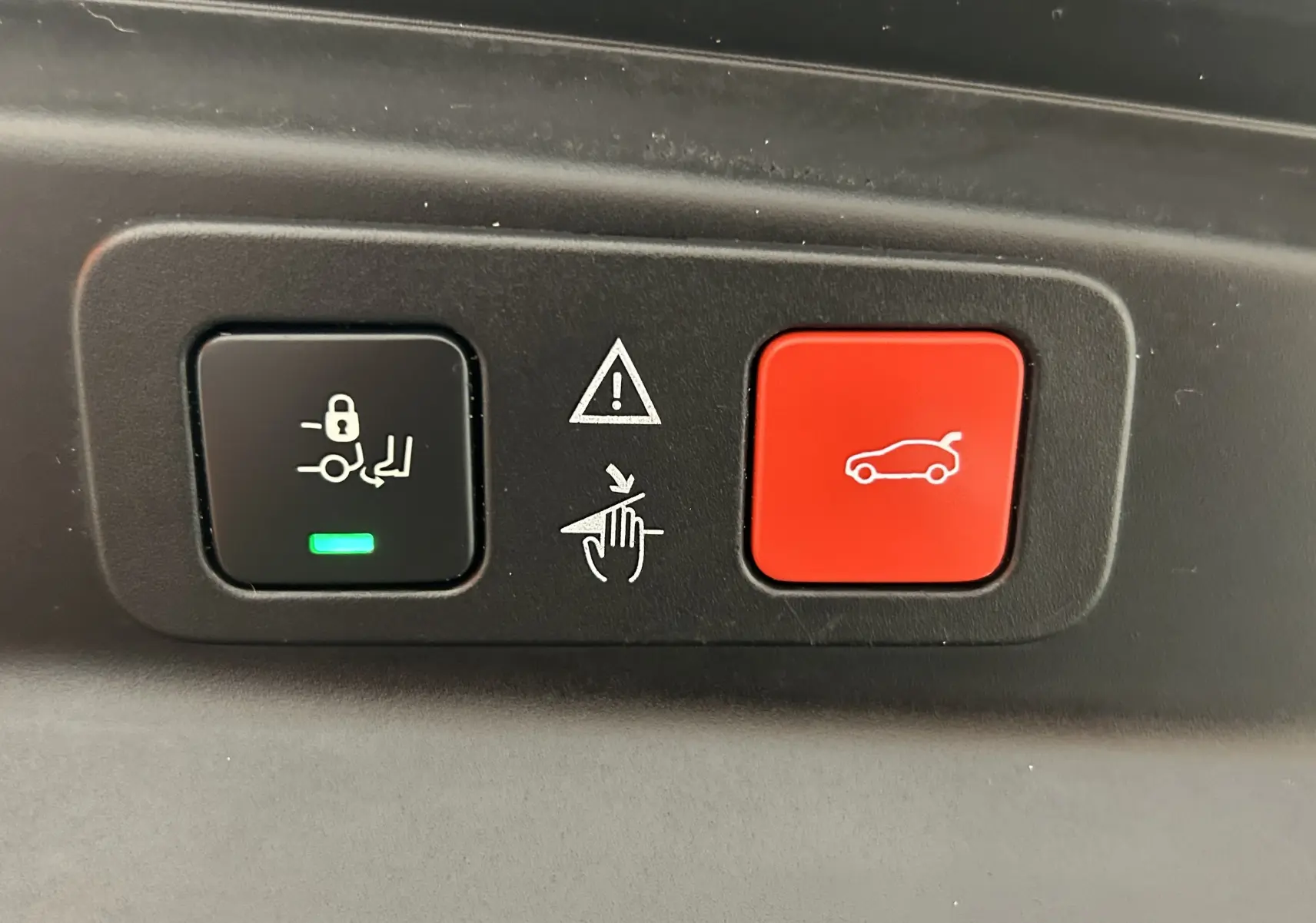 Gros plan sur les boutons de commande du hayon électrique et du verrouillage des sièges du Peugeot 5008 gris.