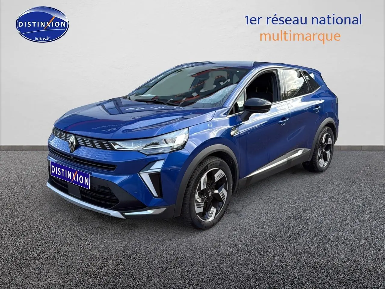 Renault Symbioz bleu iron metal en 3/4 avant droit, SUV hybride avec barres de toit et jantes stylisées.