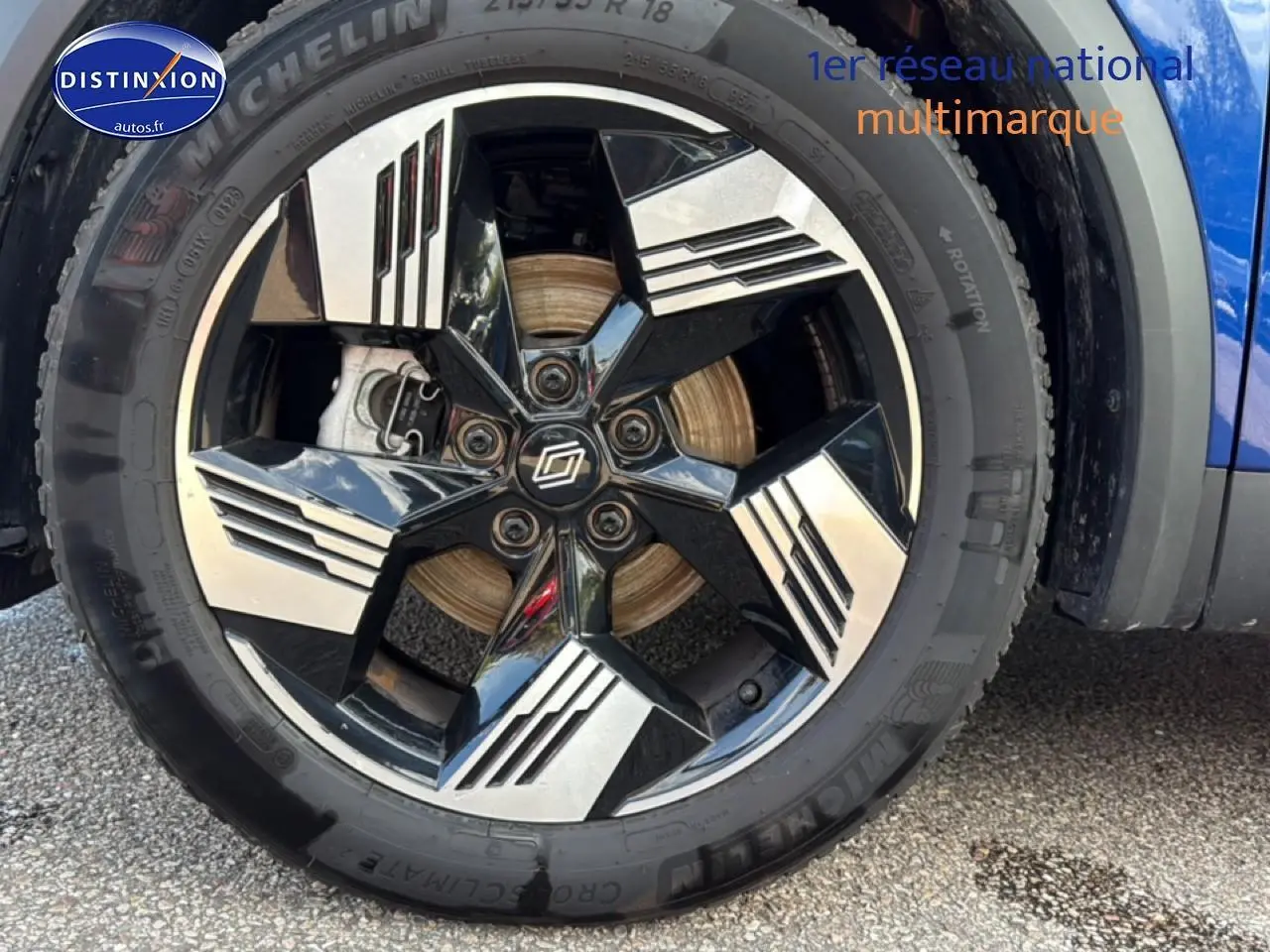 Gros plan sur la roue avant droite du Renault Symbioz bleu iron metal, jante noire et argentée au design moderne.