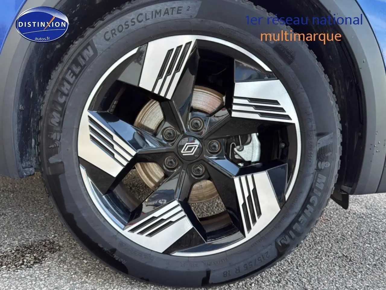 Gros plan sur la roue avant droite du Renault Symbioz bleu iron metal avec jante noire et argentée au design moderne.