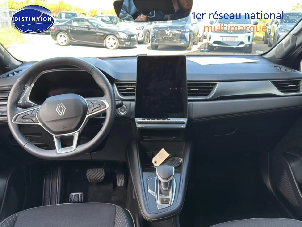 Vue intérieure avant du Renault Symbioz 2025, tableau de bord moderne avec grand écran tactile vertical et volant multifonction.