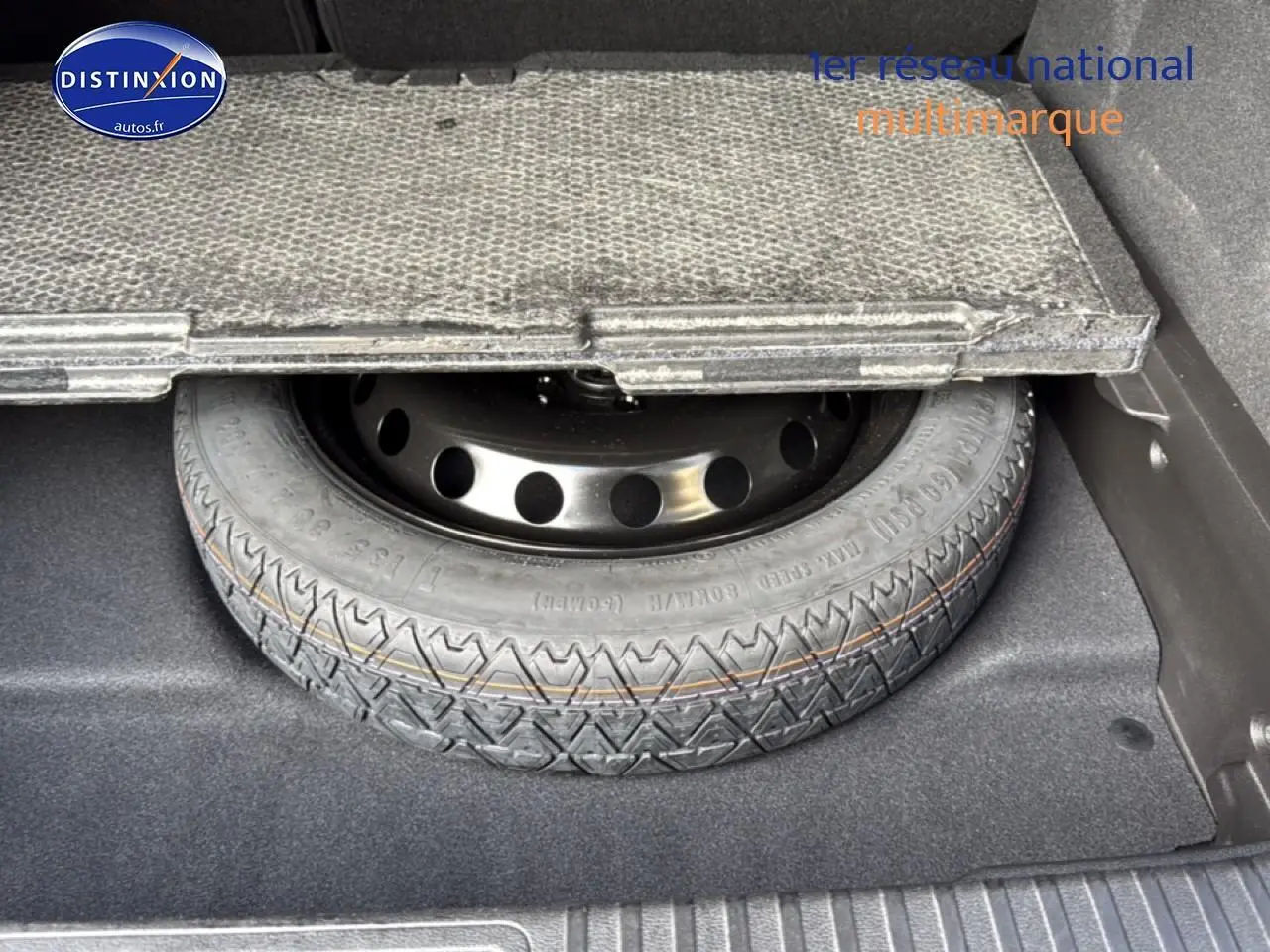 Gros plan sur la roue de secours temporaire sous le plancher du coffre du Renault Symbioz bleu iron metal.