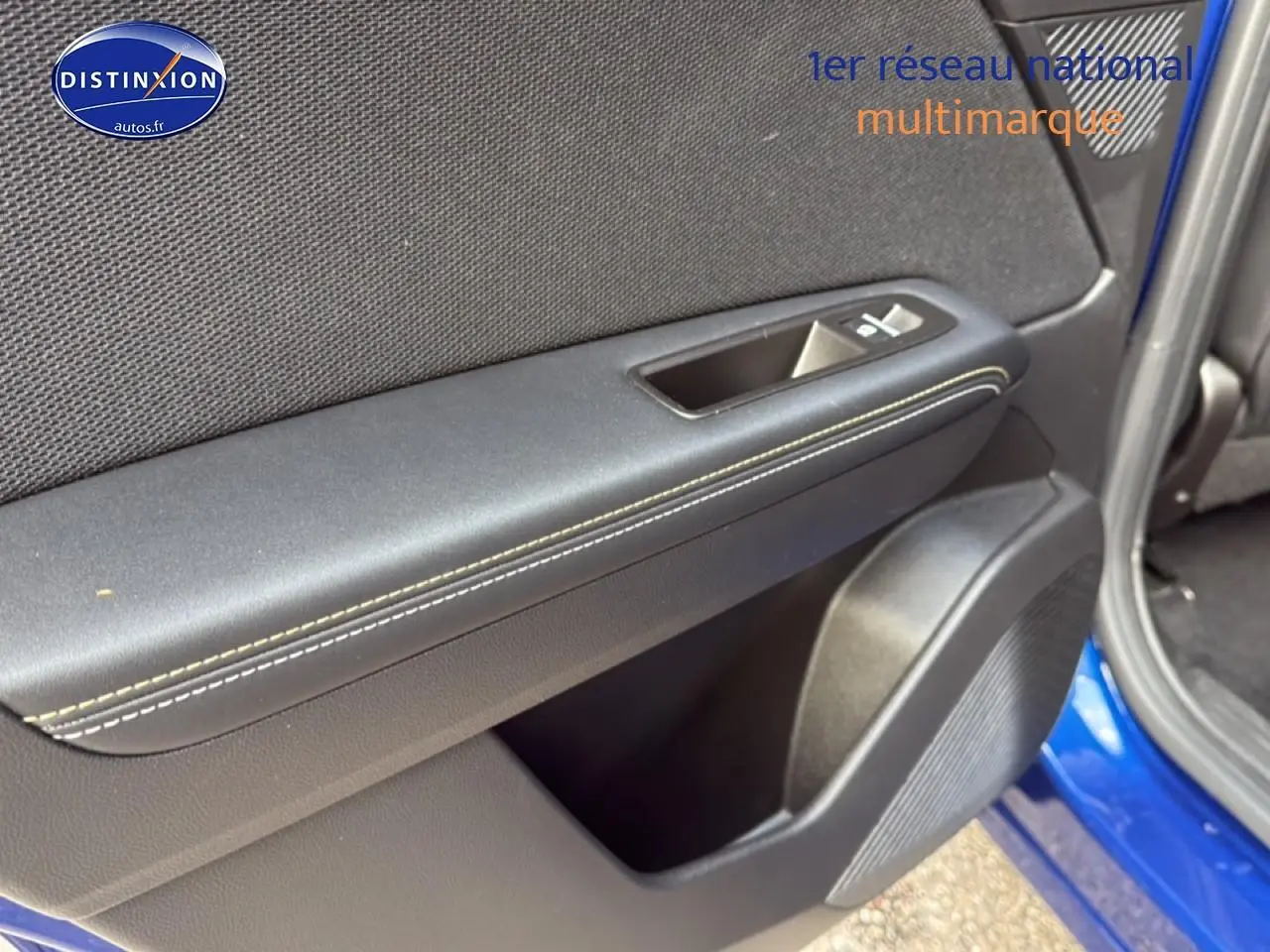 Détail de la porte avant gauche bleu iron metal de la Renault Symbioz 2025, avec commande de vitre et haut-parleur intégré.