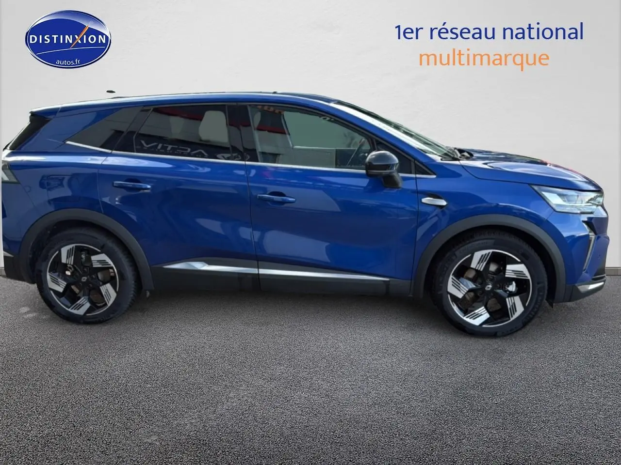 Vue latérale droite du Renault Symbioz 2025 bleu iron metal avec jantes distinctives et barres de toit.