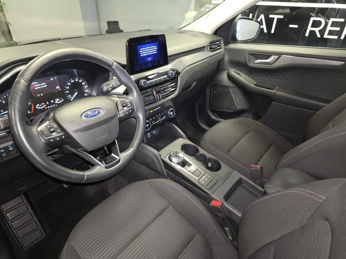 Vue intérieure avant droite du Ford Kuga 1.5 EcoBlue 2020, avec volant multifonction, écran tactile et sellerie tissu noire.