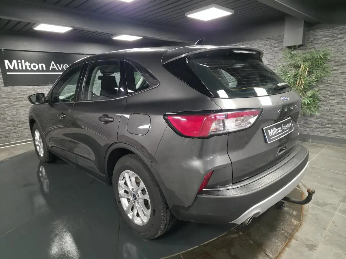 Vue 3/4 arrière droite du Ford Kuga gris métallisé 2020 avec attelage fixe et jantes alliage 17 pouces.