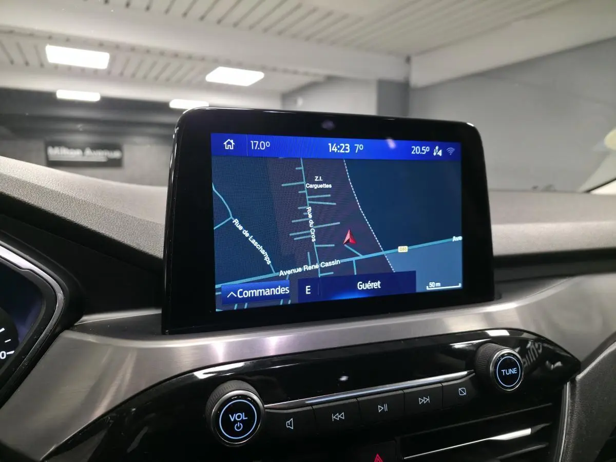 Écran tactile central du Ford Kuga 2020 affichant la navigation, avec console en finition métal brossé et boutons noirs.